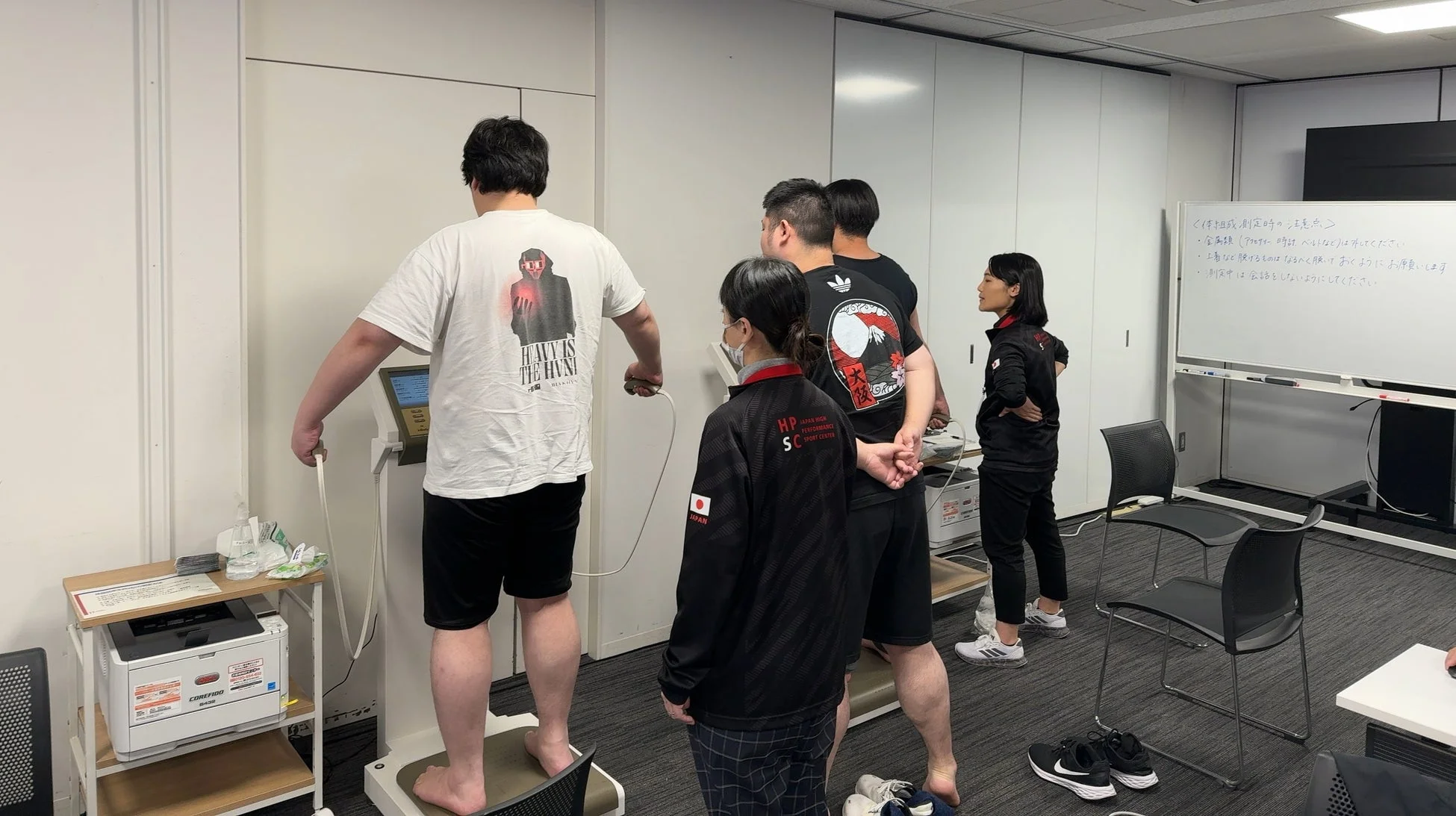 体組成測定を行うアスリートとスタッフ