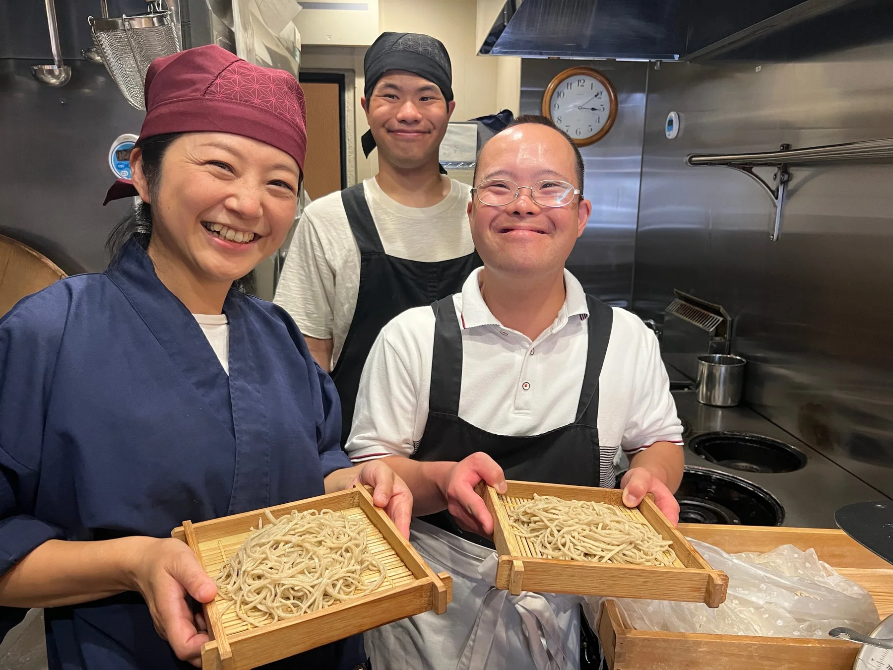完成したそばを持つ人々