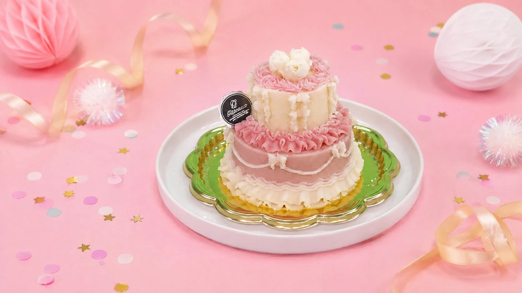 リボンや紙吹雪で飾られた二段の華やかなケーキ