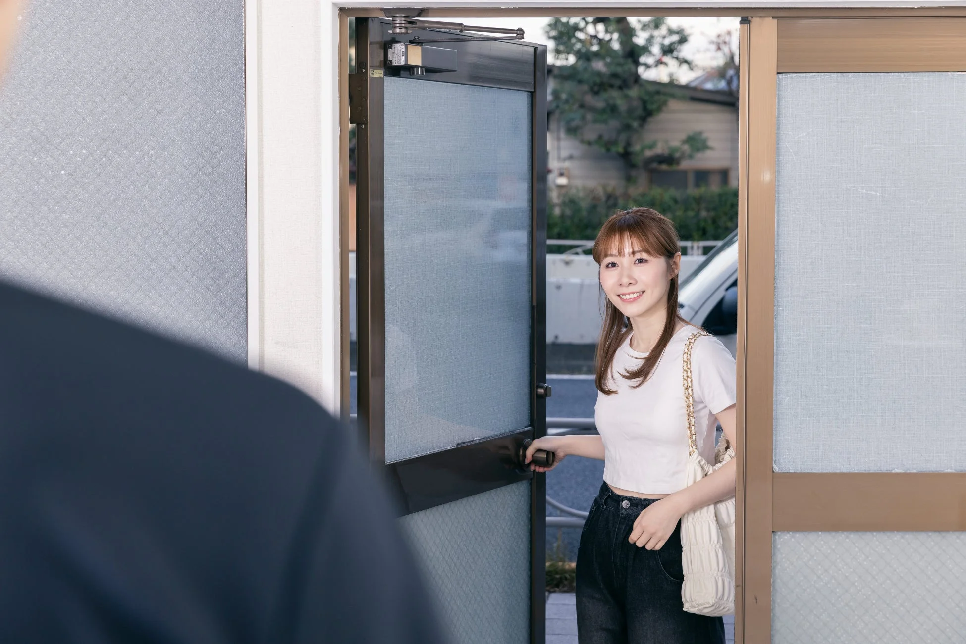 笑顔の女性がドアを開ける