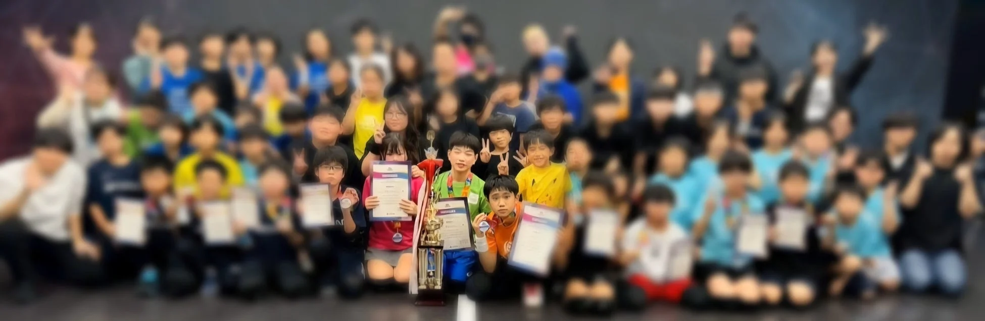 多くの子どもたちと数人の大人が集まって撮影された集合写真