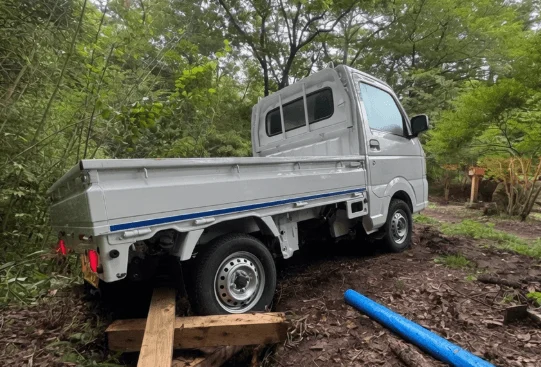 ぬかるんだ道に駐車された軽トラック