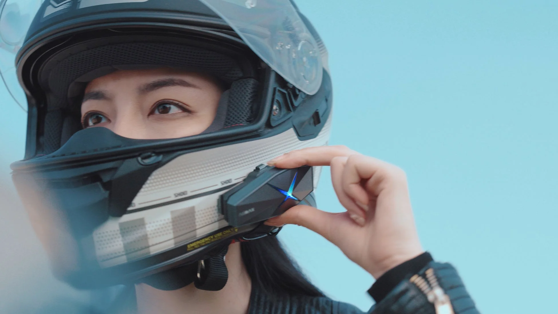 ヘルメットを装着した女性がインカムを操作