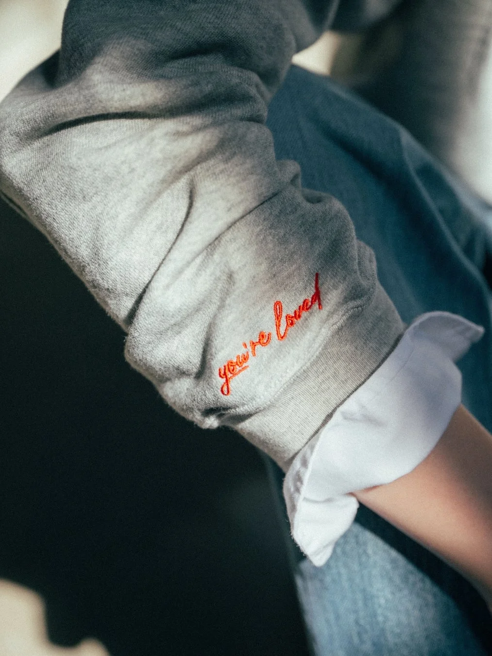 グレーのスウェットの袖の刺繍「you're loved」