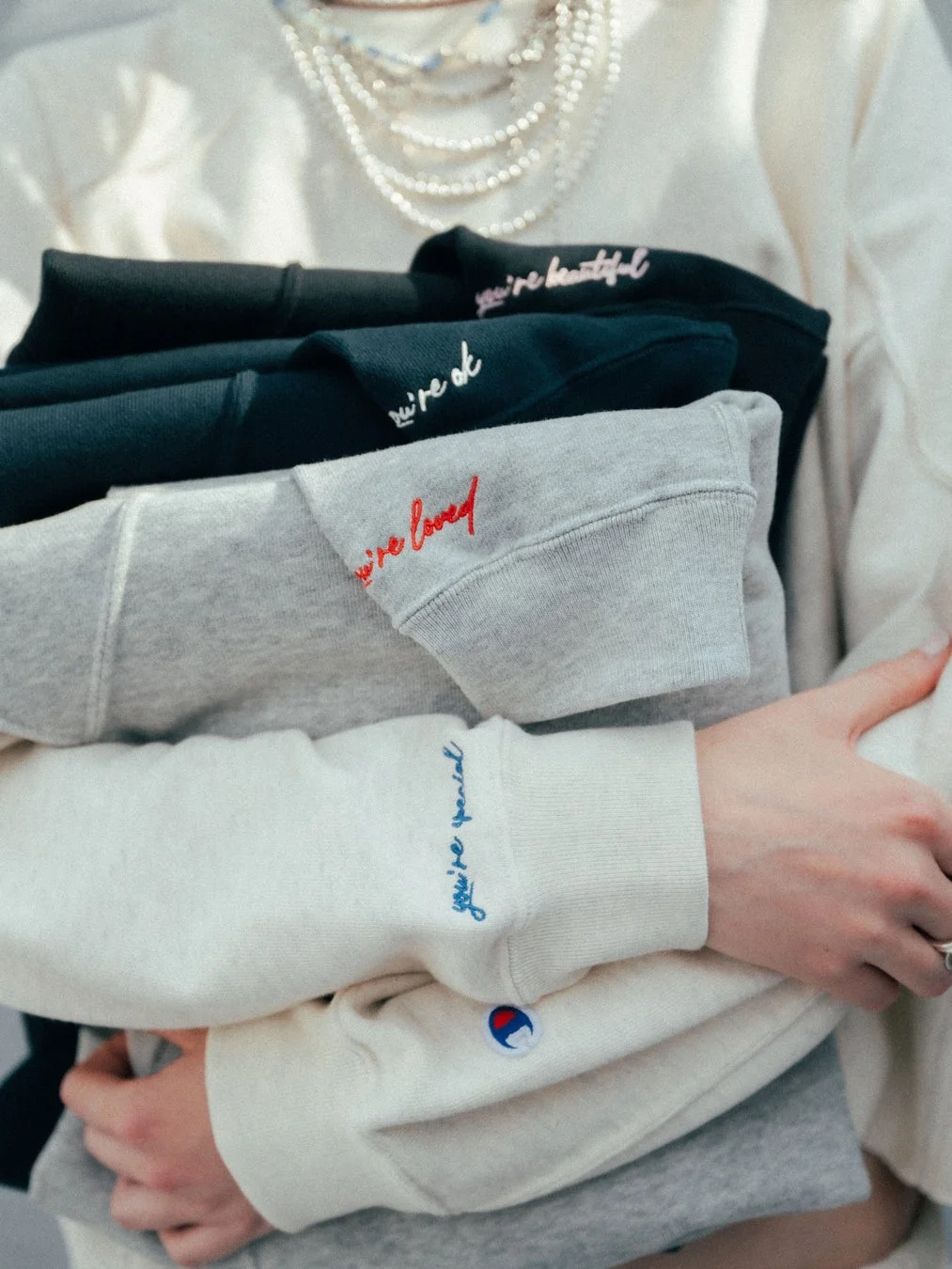 スウェットを抱える手元、メッセージ刺繍