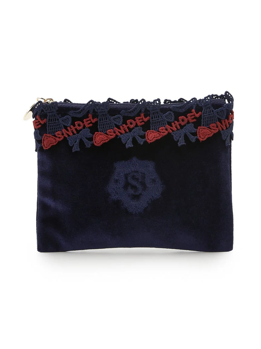 ネイビーのベルベット素材のポーチです。上部には「SNIDEL」のロゴとリボンが刺繍されたレースがあしらわれ、中央にはブランドのエンブレムのようなデザインが施されています。
