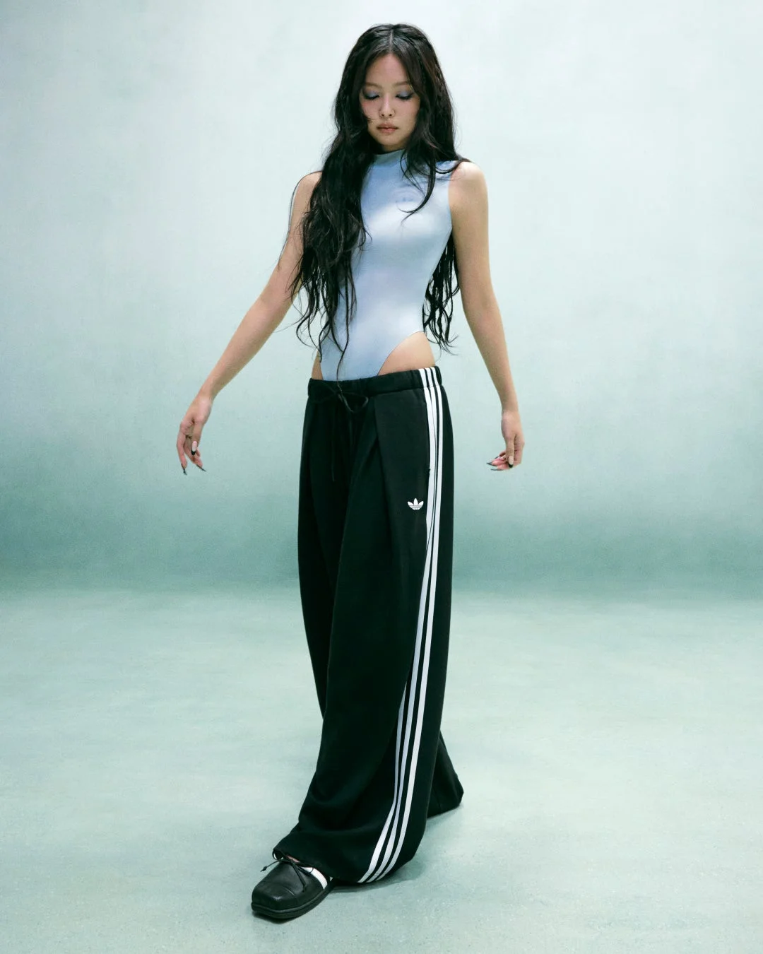 JENNIEが水色のボディースーツと黒いトラックパンツを着用