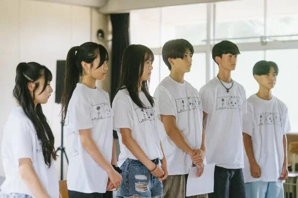 白いTシャツを着て整列する若者グループ