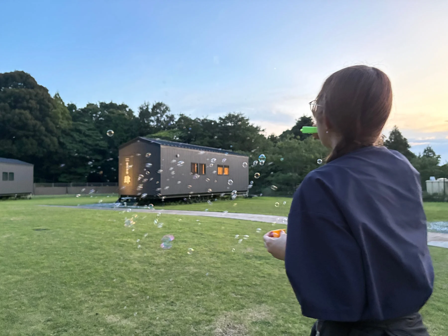 夕暮れ時にシャボン玉を飛ばす女性