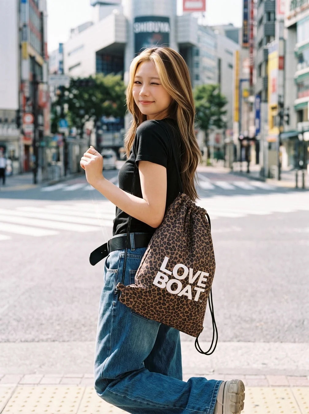 女性がヒョウ柄の巾着バッグを持ったストリートファッション
