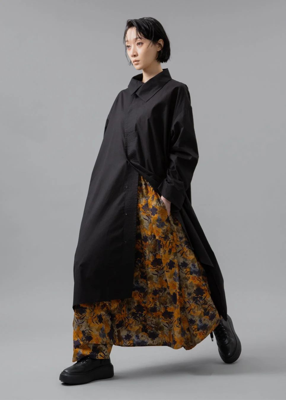 女性、黒いロングシャツ、花柄ワイドパンツ