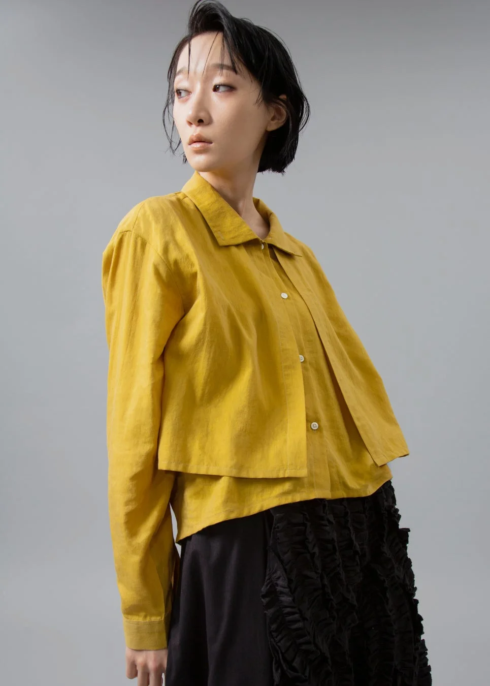 女性、ショートヘア、黄色シャツ、黒スカート