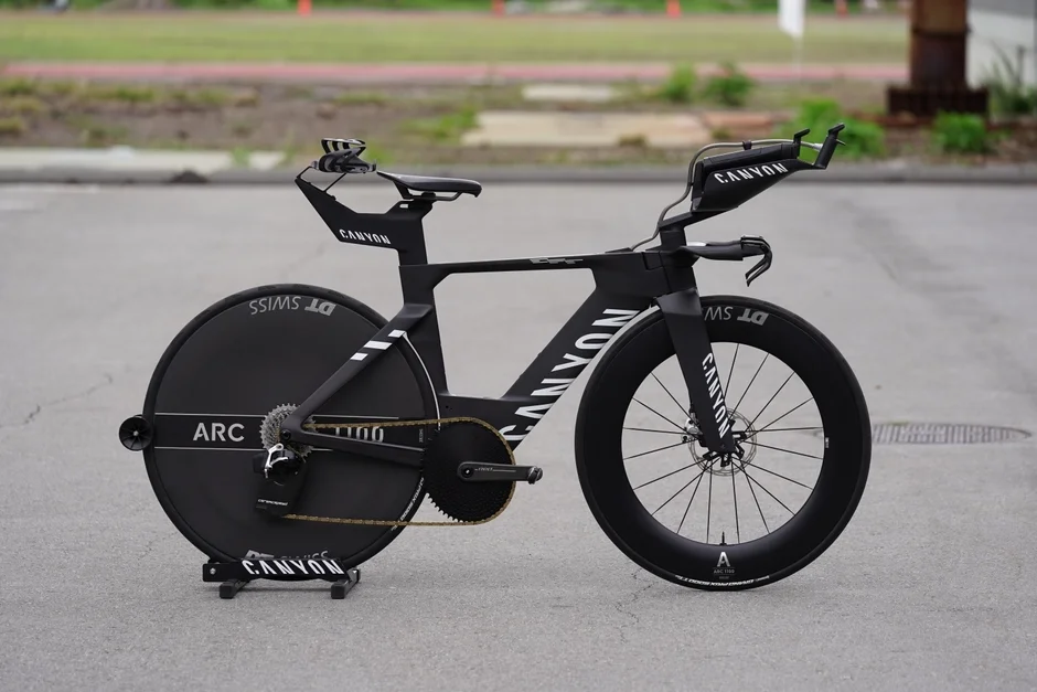 黒いCANYON製タイムトライアルバイクが舗装路に停車しています。