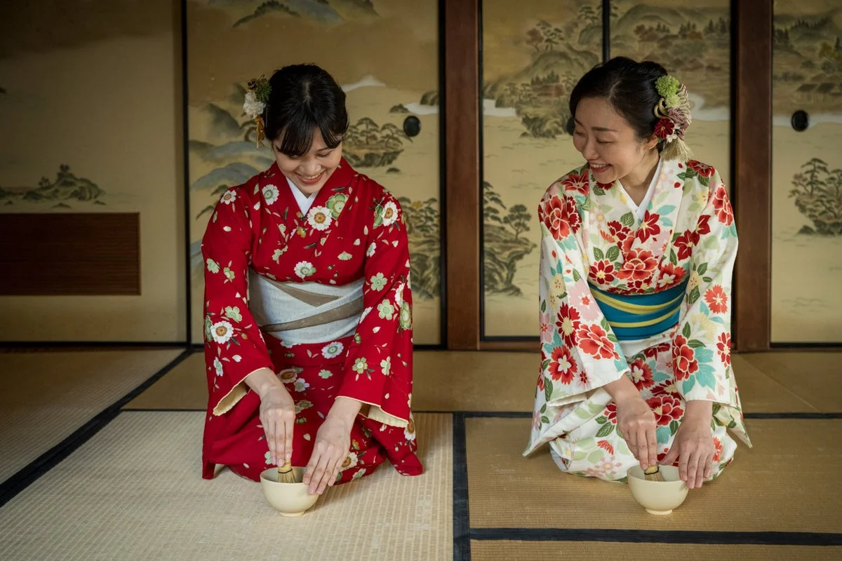 着物を着た女性が抹茶を点てる