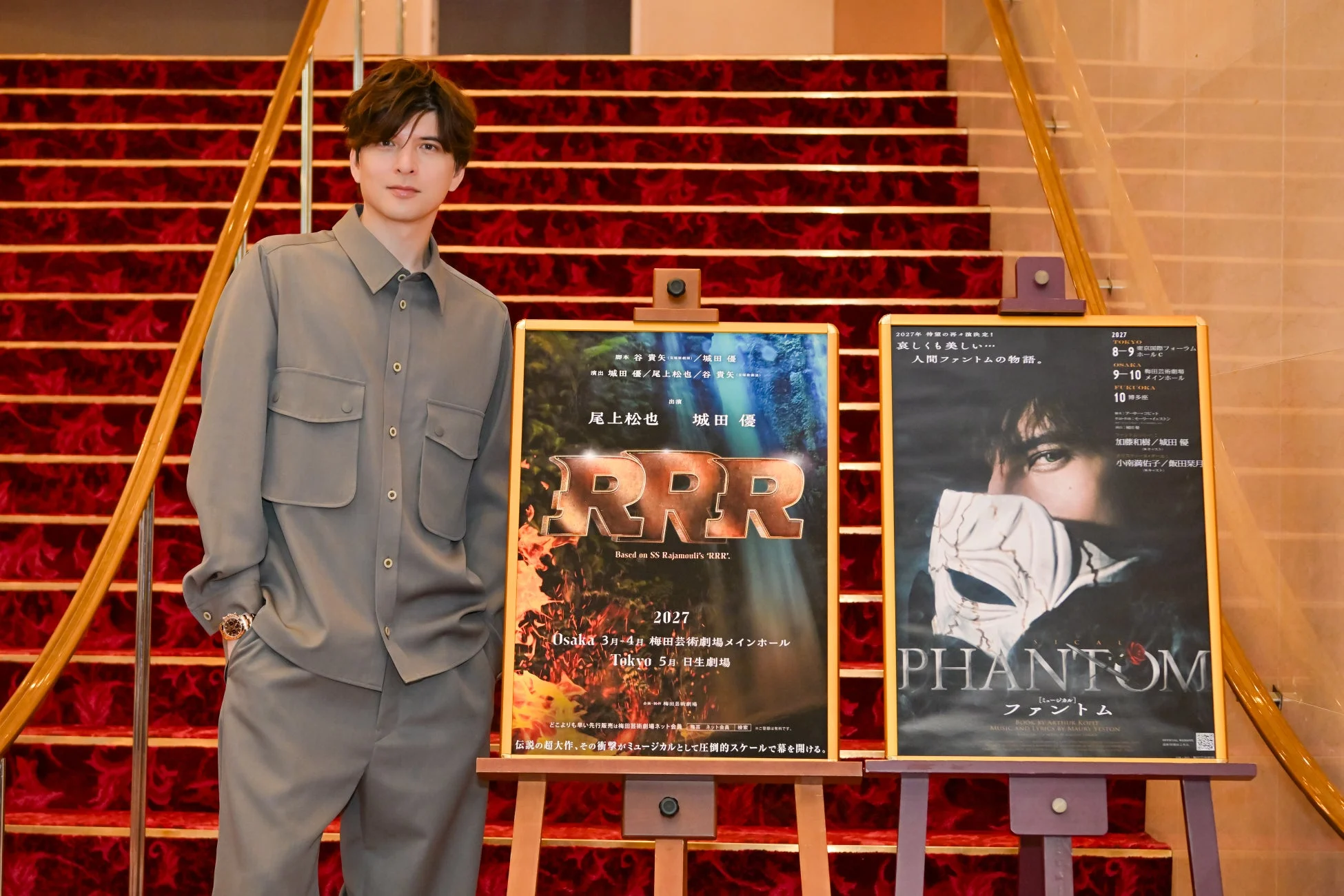 ミュージカルのポスターを背景に立つ城田優氏