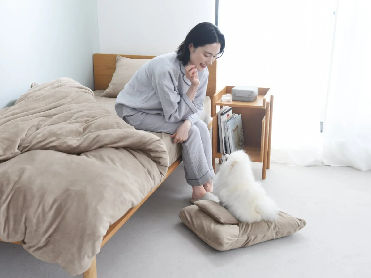 寝室で犬とリラックスする女性