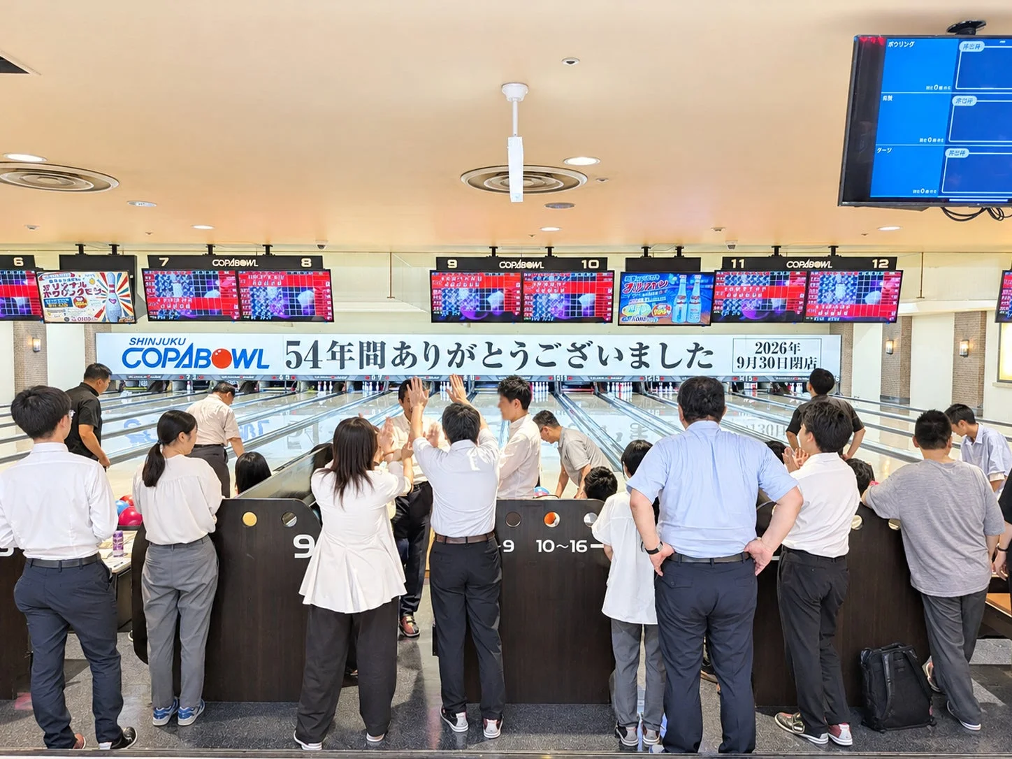 ボウリング場で楽しむ人々、閉店告知の横断幕