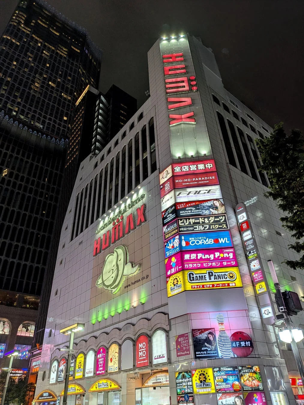 夜の繁華街のビル、HUMAXの広告