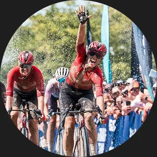泥だらけの自転車レースで女性サイクリストが勝利を喜ぶ