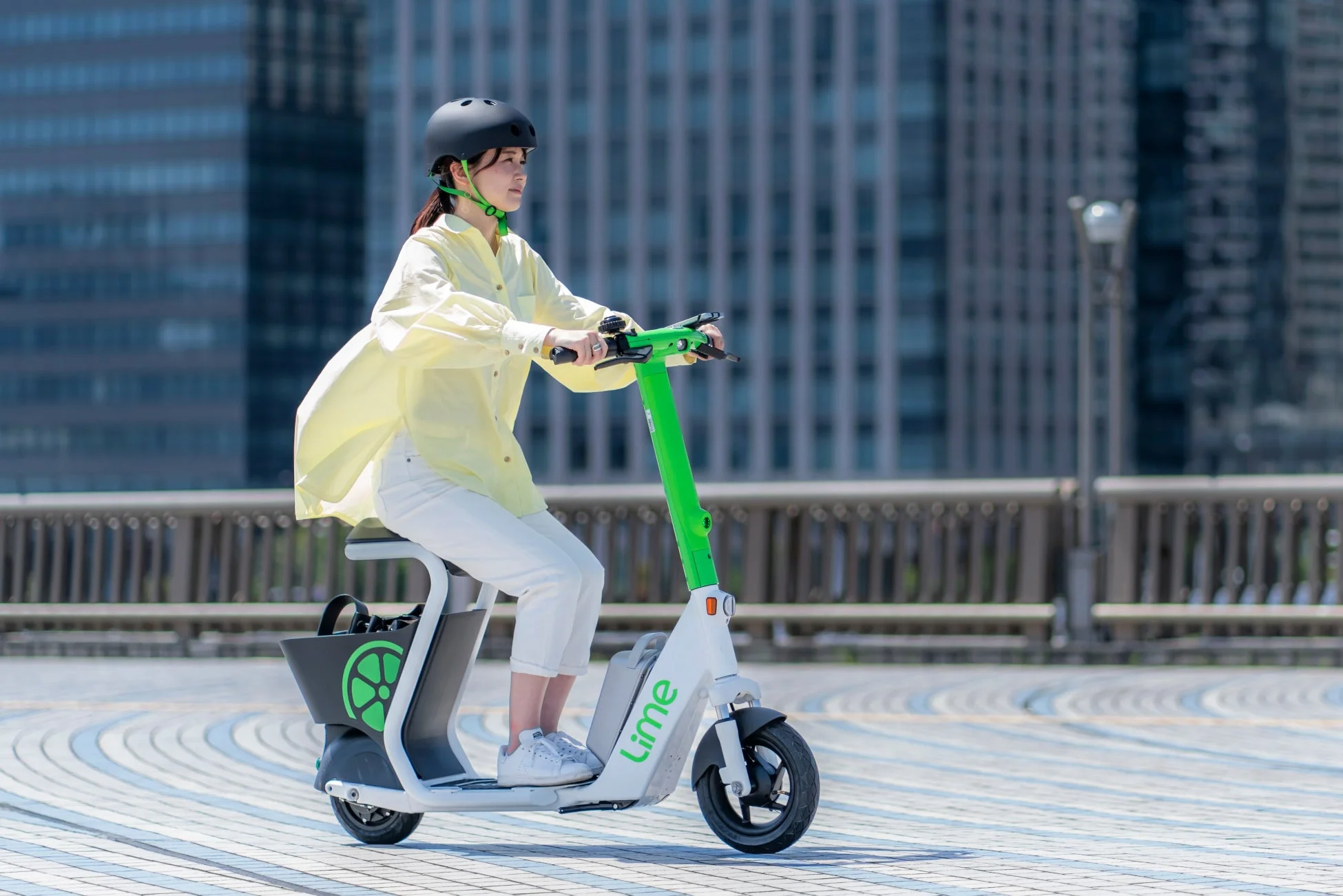 都市部で電動キックボードに乗る女性